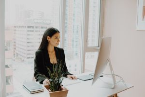 woman using a white computer | luxury homes by brittany corporation