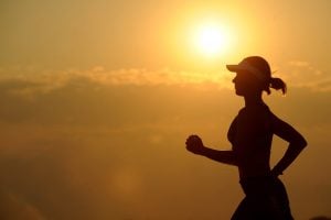 woman with white sunvisor running | luxury homes by brittany corporation