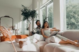 Photo of a couple and a dog sitting on a couch. | luxury homes by brittany corporation