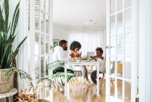 Photo of a couple and a kid eating on a wooden dining table. | luxury homes by brittany corporation