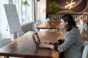 Photo of a woman in a striped, long-sleeve using a silver Macbook. | luxury homes by brittany corporation