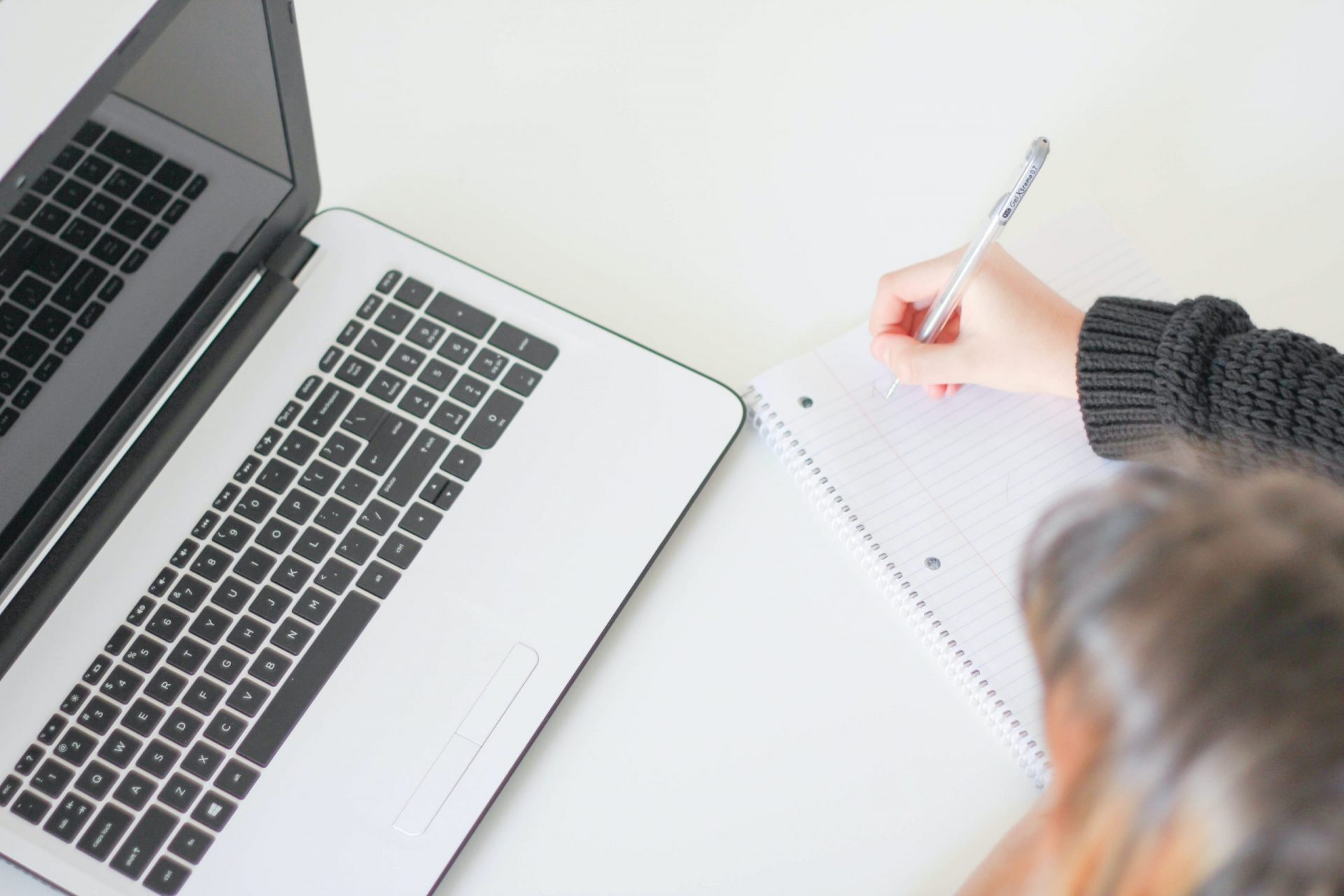 Photo of a woman writing on a notebook. | luxury homes by brittany corporation