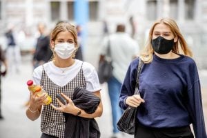 two fashionable women in face masks holding a lot of things | luxury homes by brittany corporation