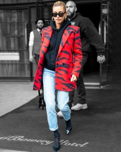 woman wearing a red coat over simple clothes and ripped jeans | luxury homes by brittany corporation
