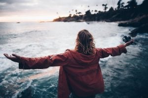 woman wearing red jacket breathing in the sea scent | luxury homes by brittany corporation