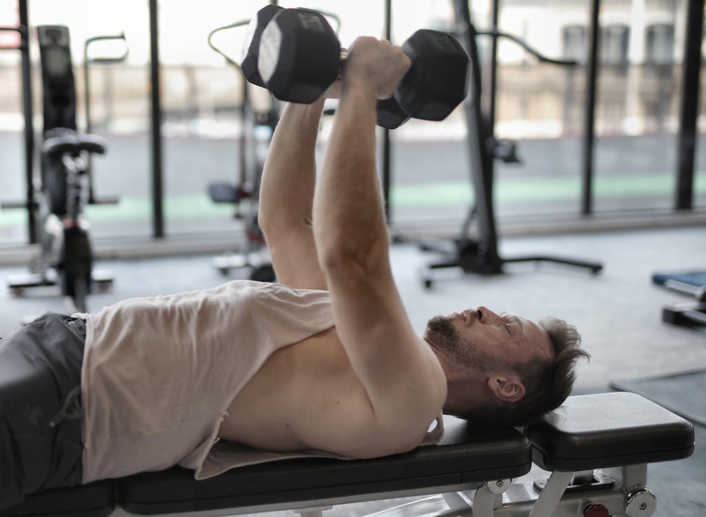 Use a weight bench to support you in various exercises. Photo from Pexels.