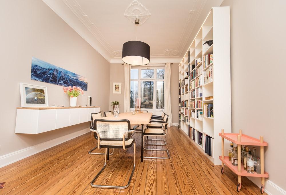 What is a home library white and black chairs on brown wooden floor