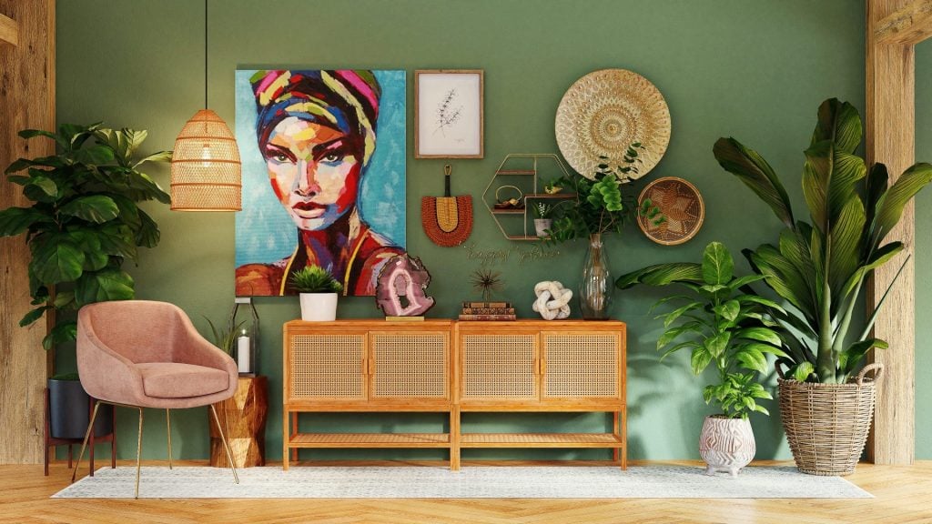 Photo of green wall decorated with paintings, plant accents, and wooden furnishings