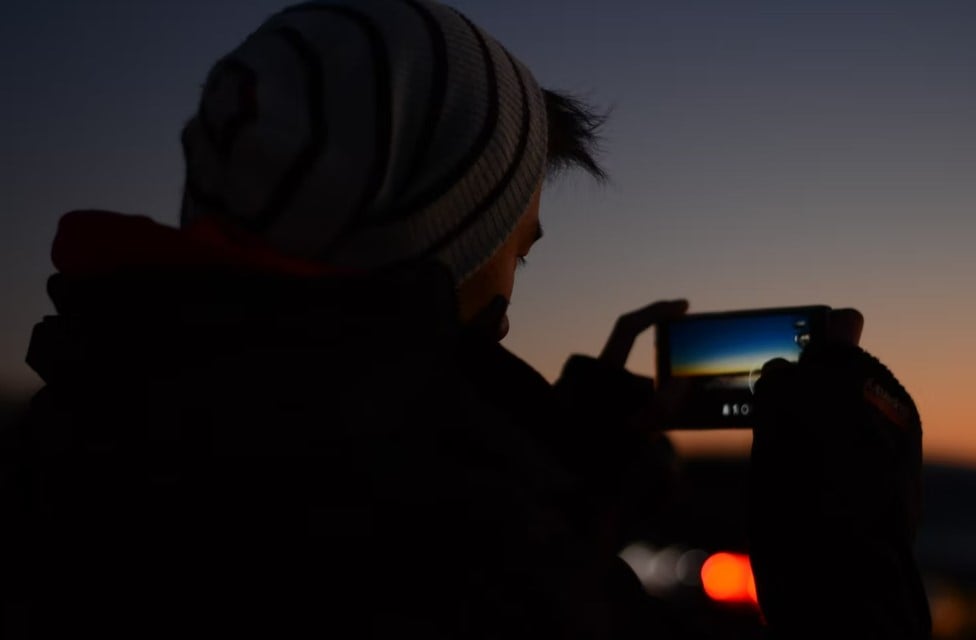 man holding phone to take a picture