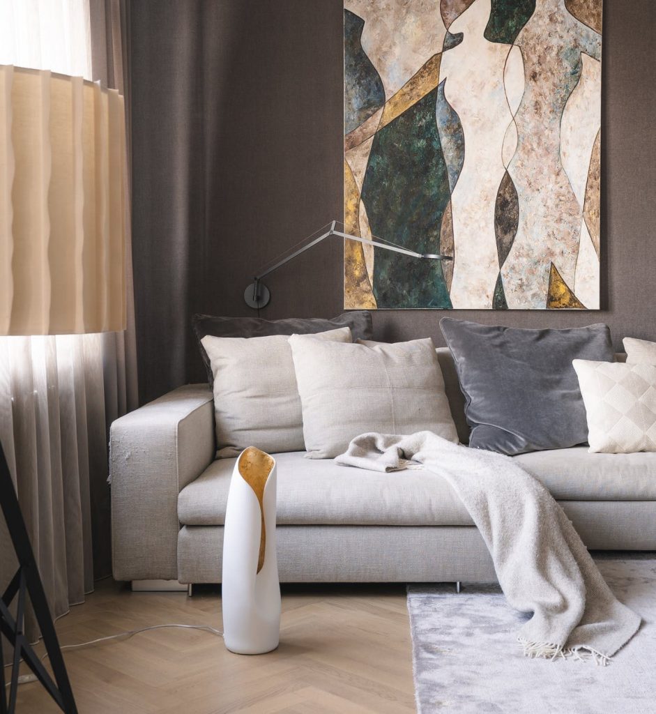 Image of a neutral color couch with painting on the wall