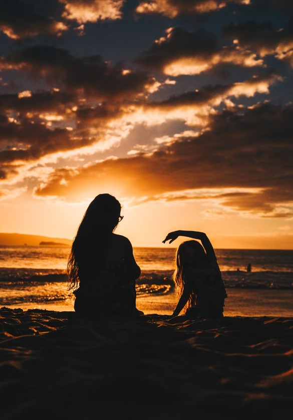silhouette photo of woman and girl on shoreline