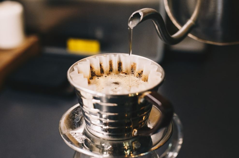 Pouring hot water over a cup of coffee