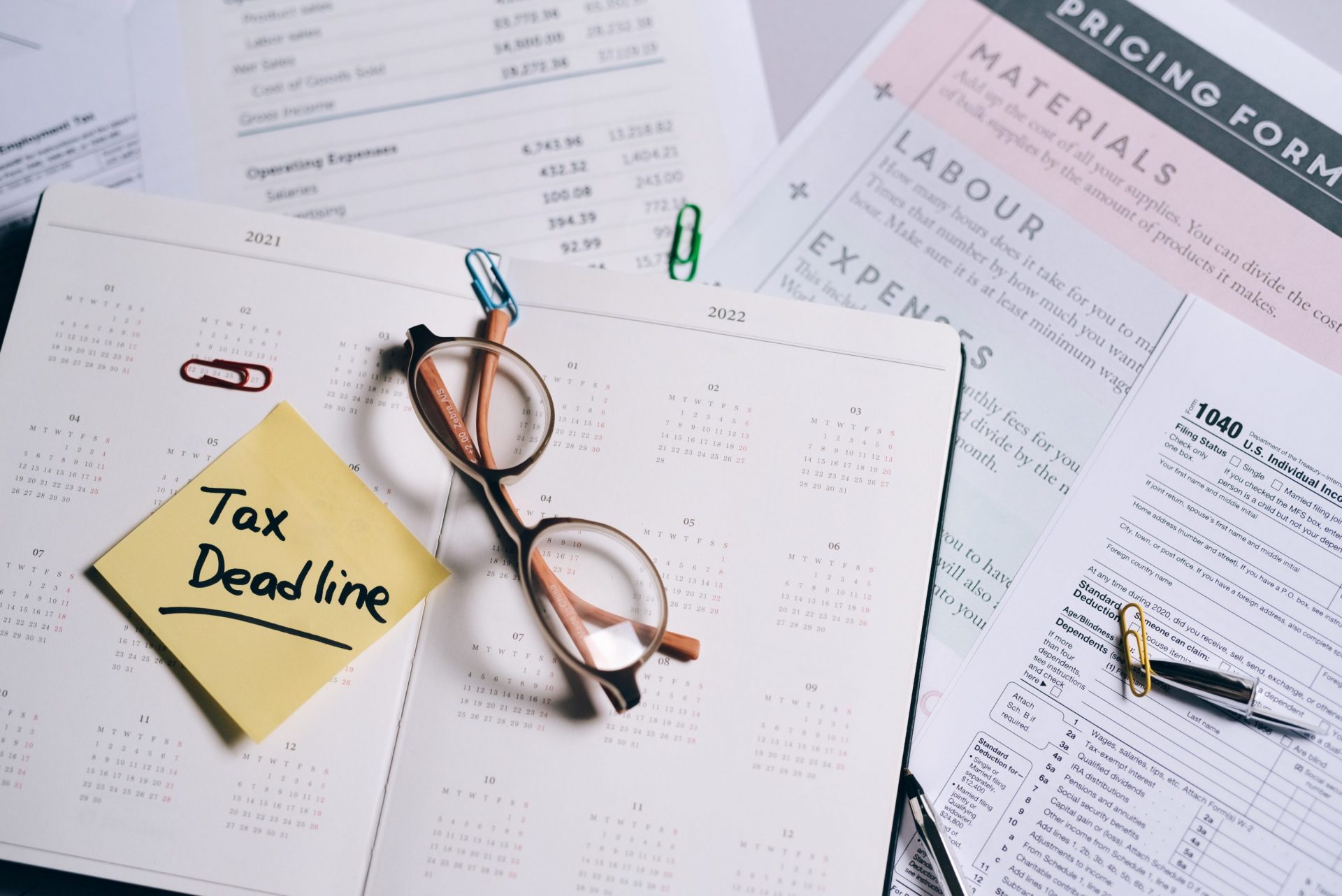 Photo of glasses on top of a notebook and other papers