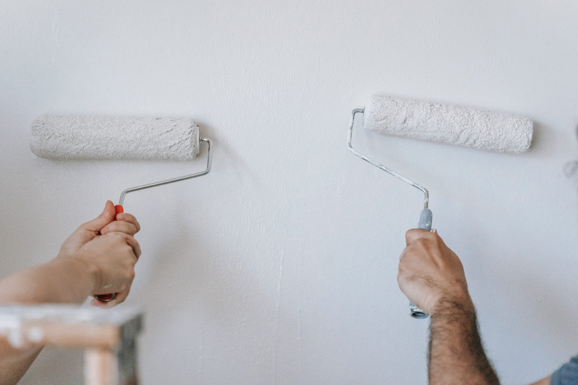 Photo of 2 people painting the wall