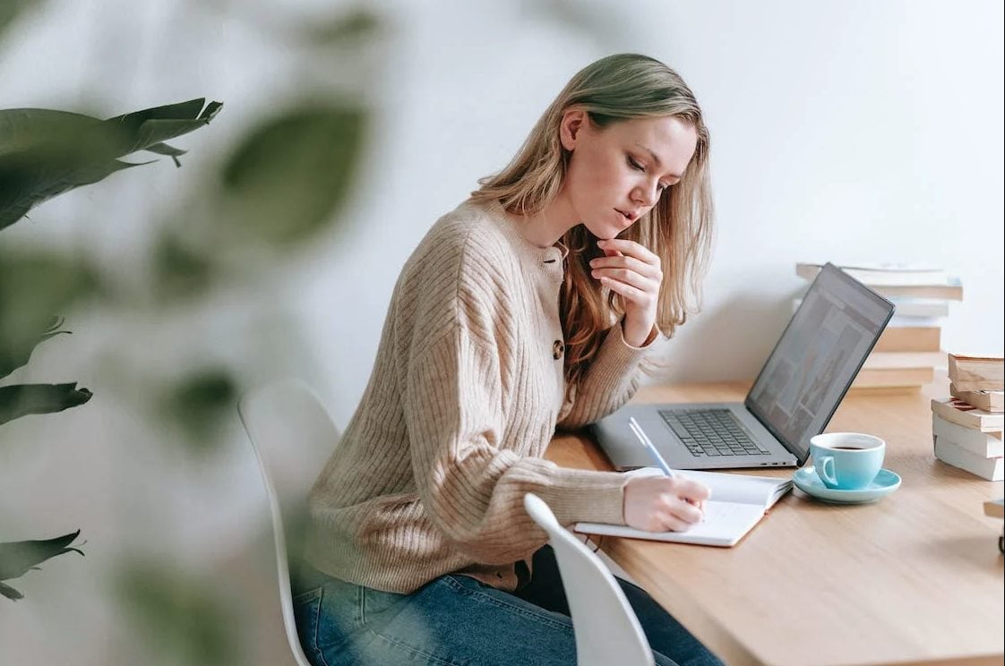 Photo of a girl thinking while writing