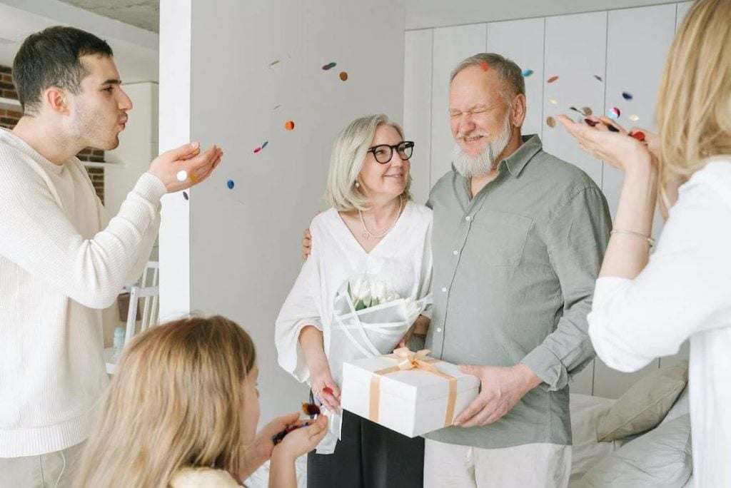 Photo of elderly couple celbrating with their family