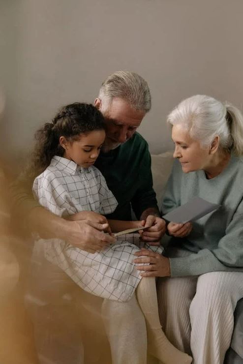Photo of elderly couple showing a paper to their grandchild