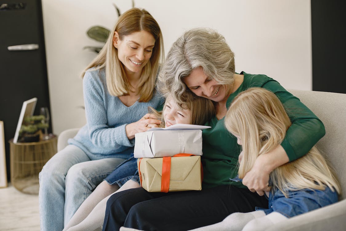 Photo of a grandmother holding gifts with her family