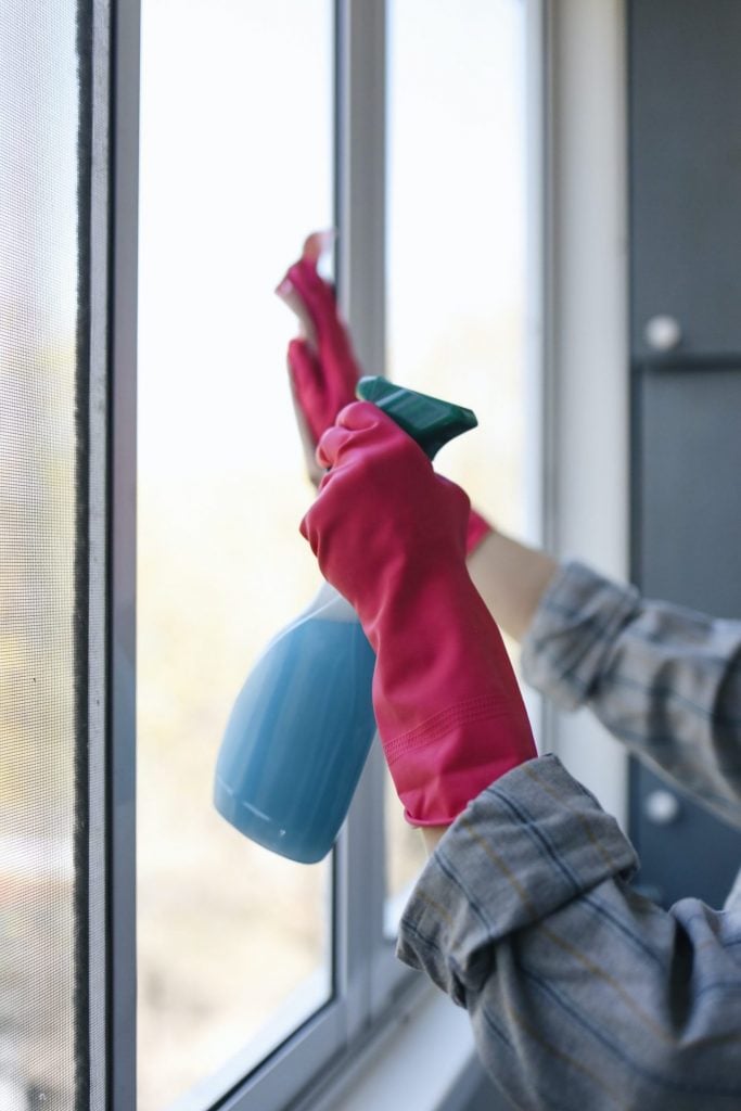 A Person Cleaning a Glass Window