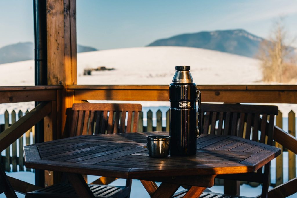 A black reusable water bottle on top of a wooden table