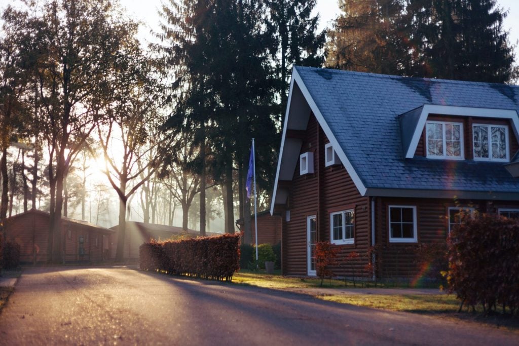 A brown house surrounded by trees on a daylight backdrop.