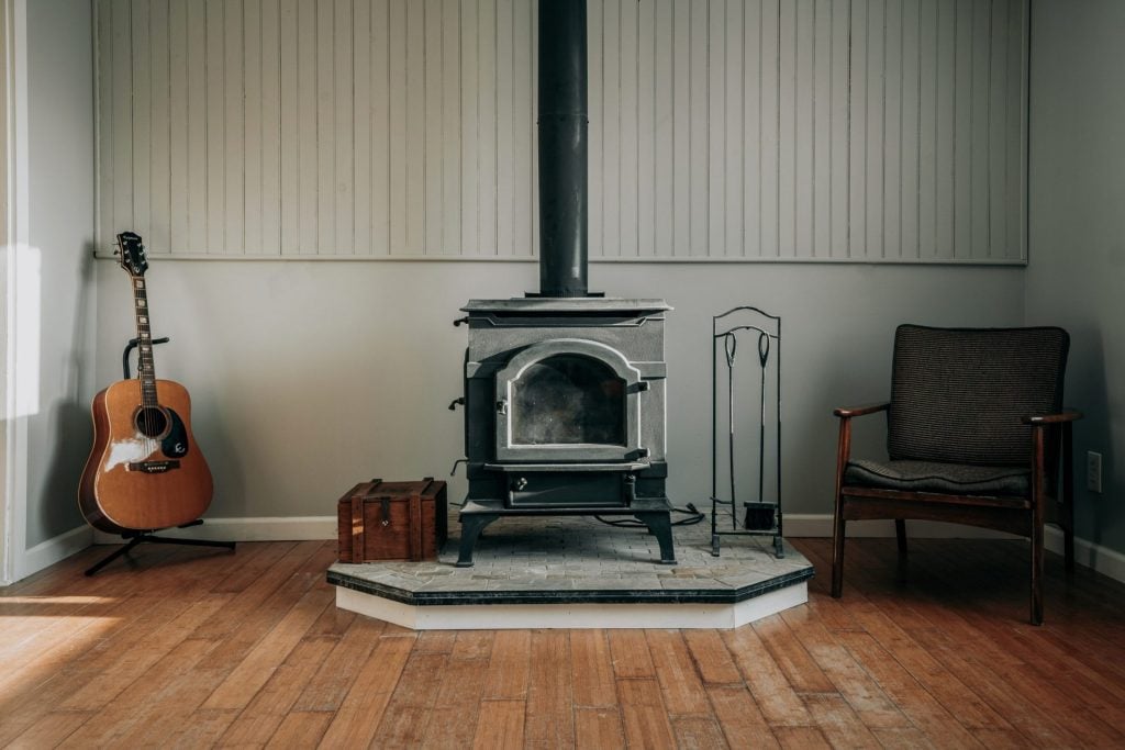 A cozy wood-burning stoves on top of a concrete platform.