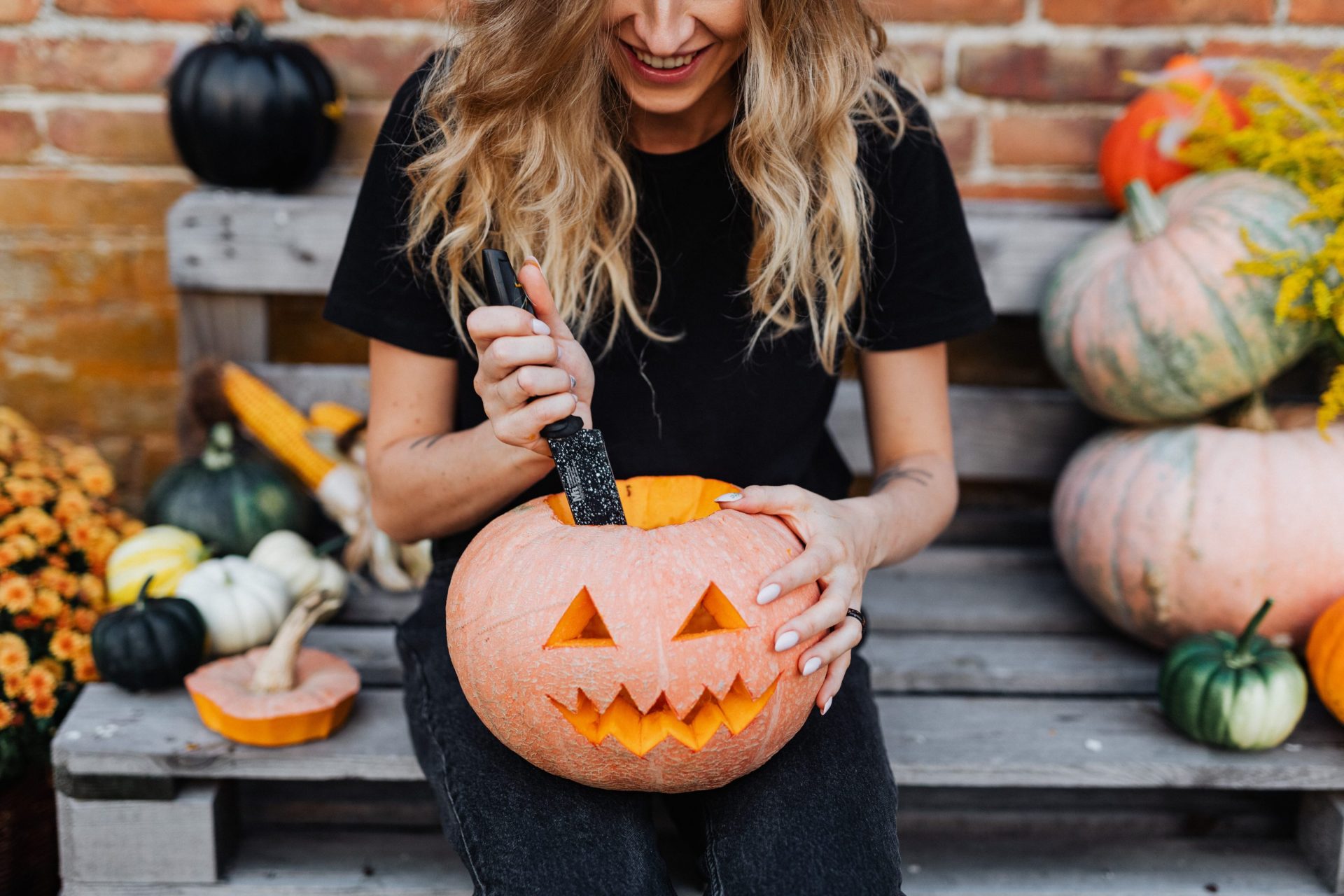 A woman carving a pumpkin head