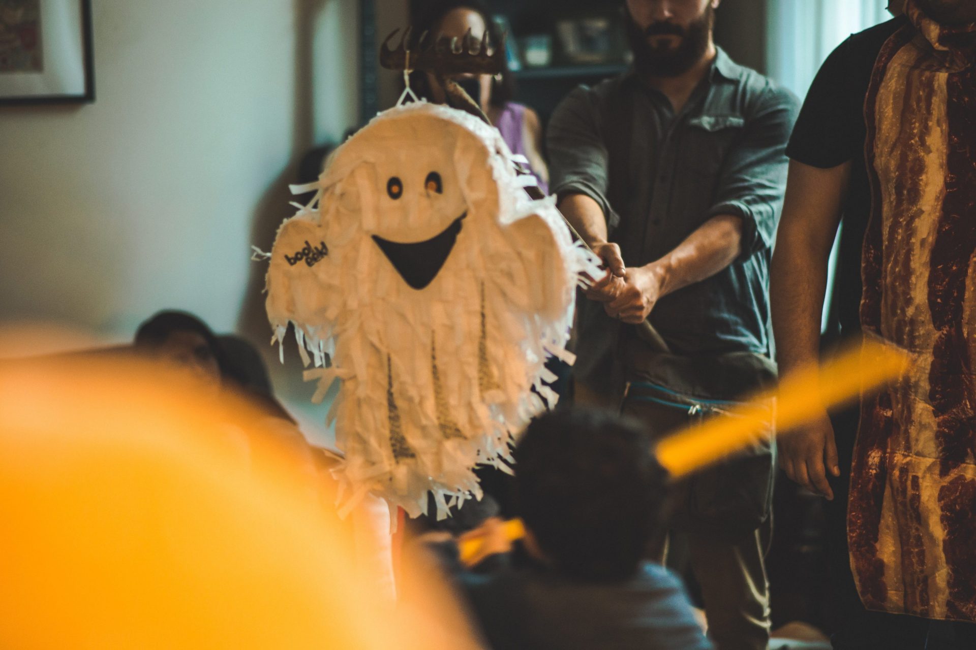 Photo of a guy hitting a halloween pinata