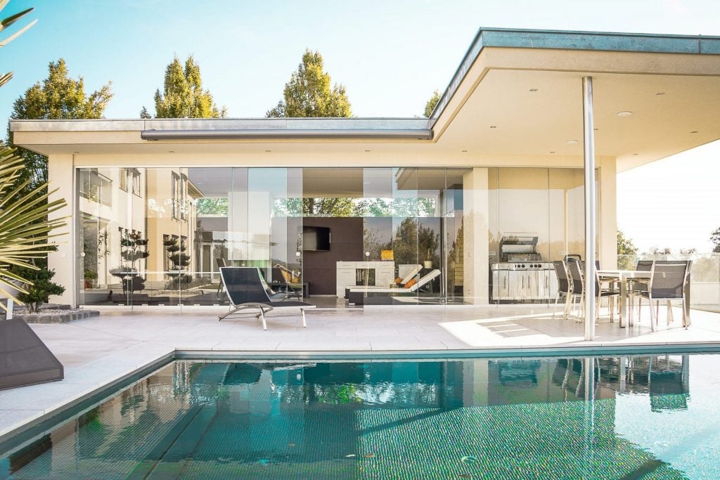 Poolside area with a covered patio and outdoor kitchen