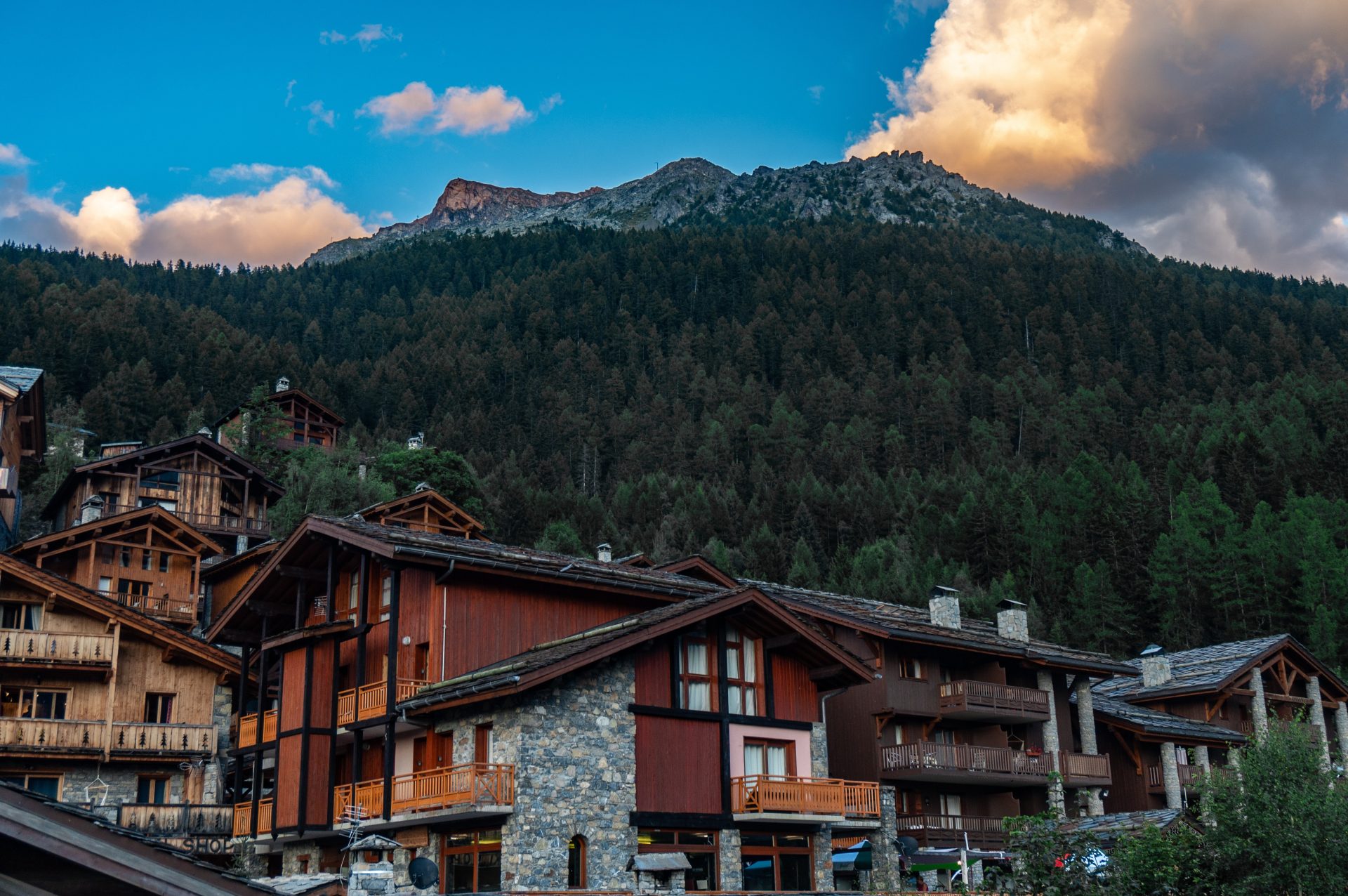 Wooden houses with sloped roofs located on the hillside.