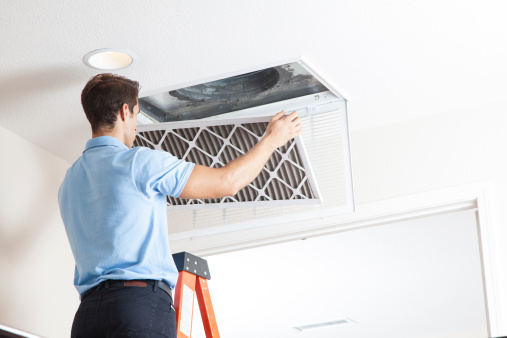 A man fixing the ventilation in the ceiling