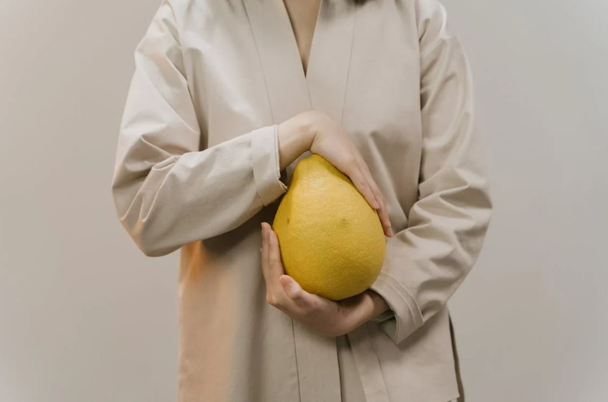 Photo of a woman holding a pomelo