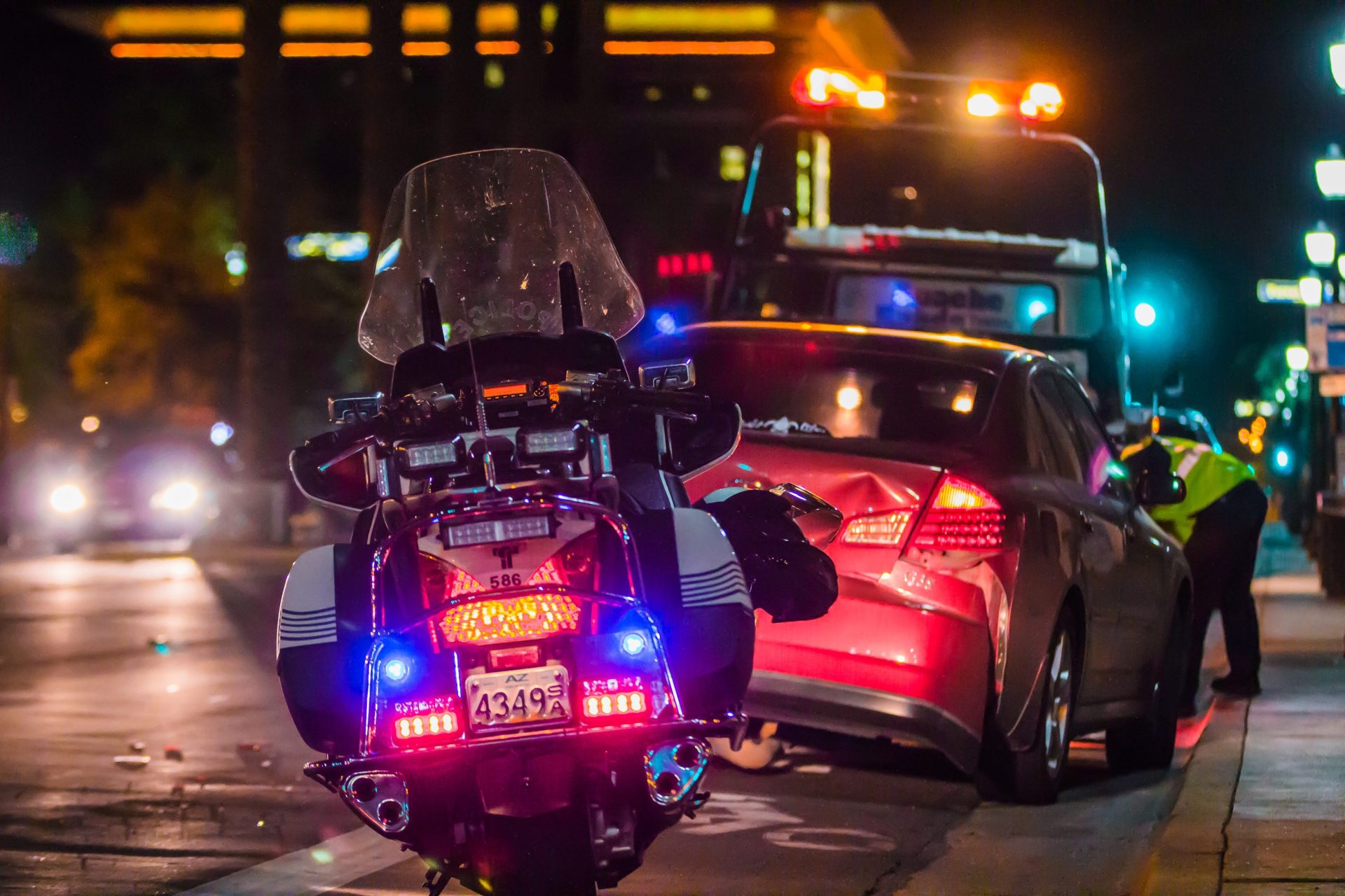 Photo of a highway patrol motorcycle at the back of a car crash