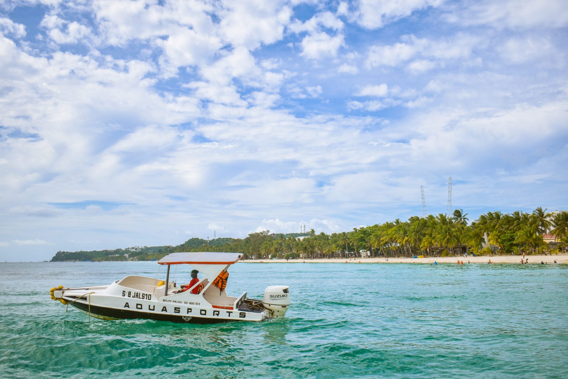 Photo of island with white boat and coconut trees