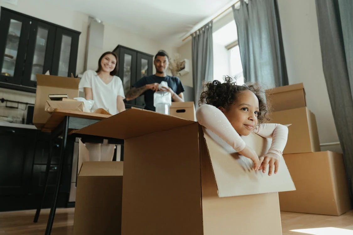 Photo of a family in the living room while the daughter is in the box