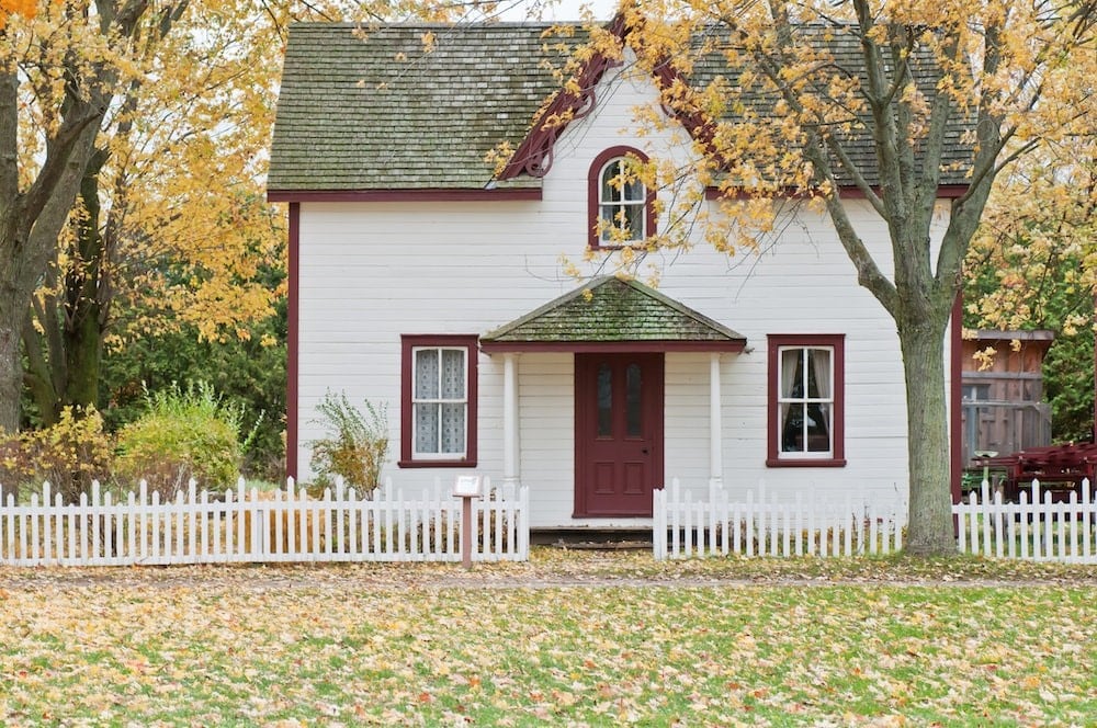 Photo of white house under maple trees