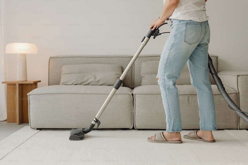Photo of a woman using a vacuum to clean a living room