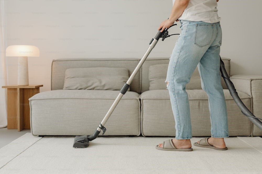 Photo of a woman using a vacuum to clean a living room