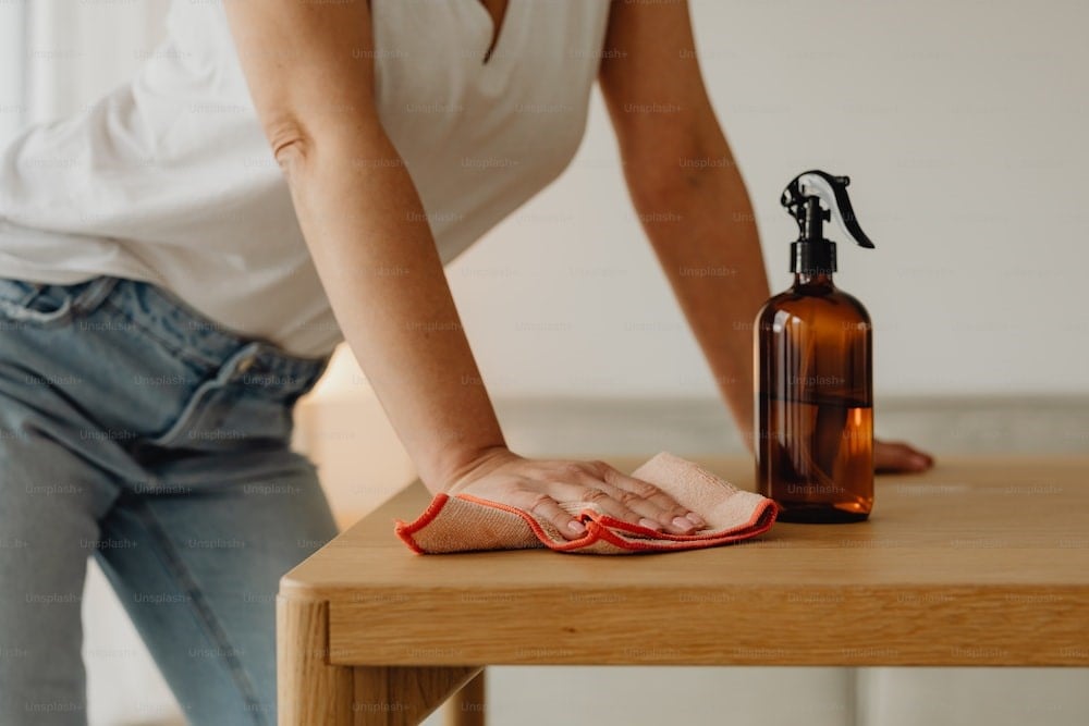 Photo a woman cleaning a table with a cloth